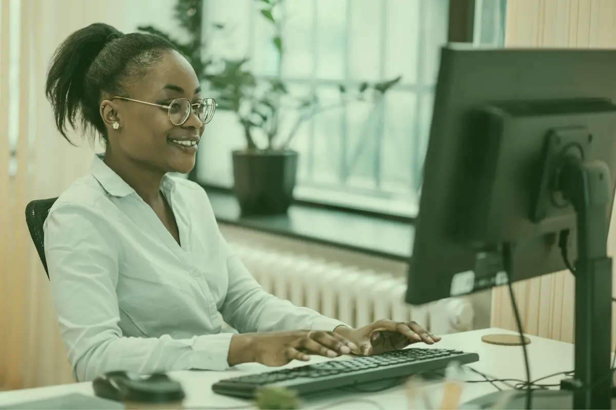 Professional working at a desktop computer in a bright office